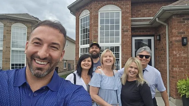 Daniel Zanettin with clients outside their new home